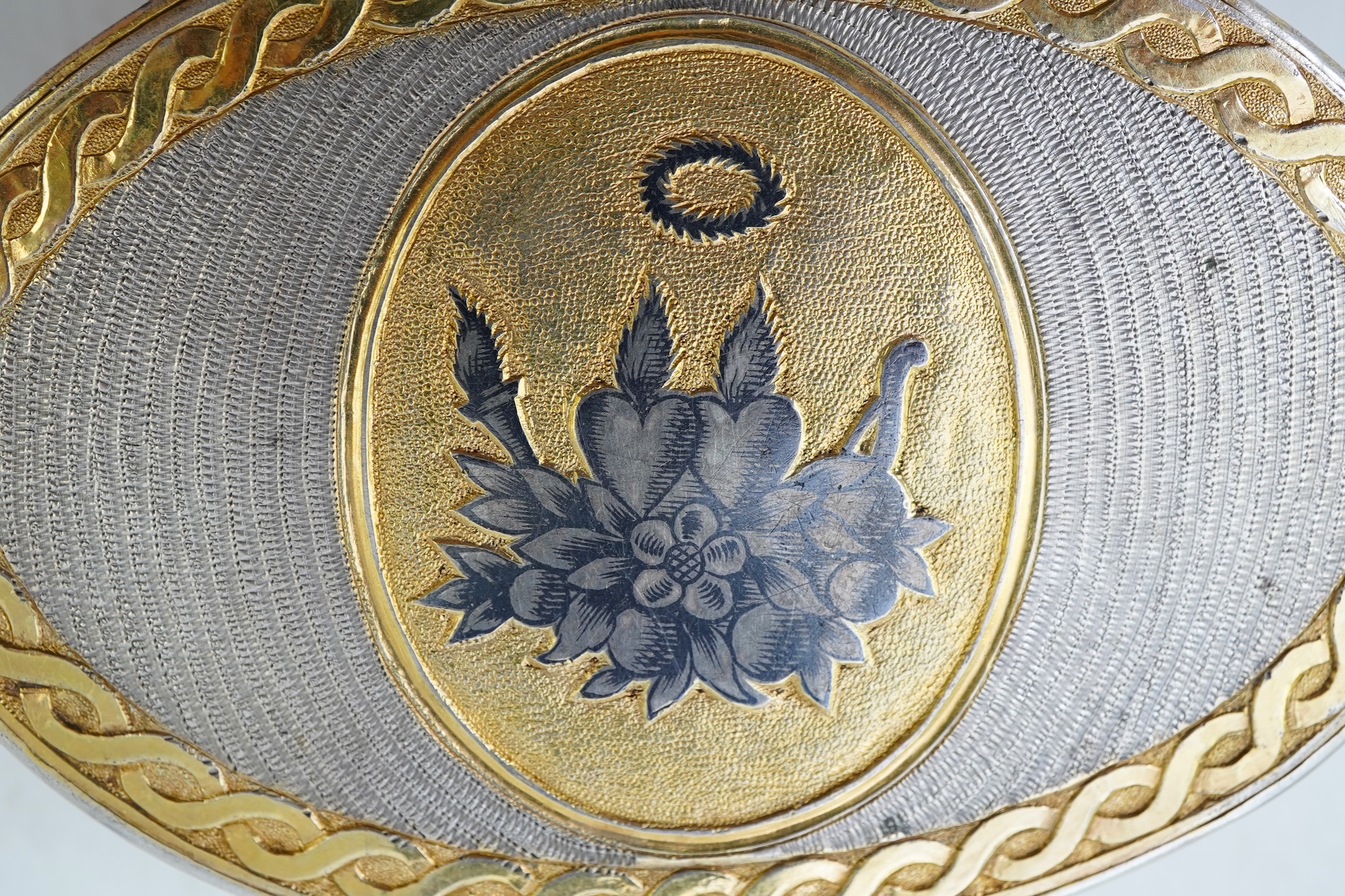 A 19th century Swiss? parcel gilt white metal oval snuff box with hinged cover